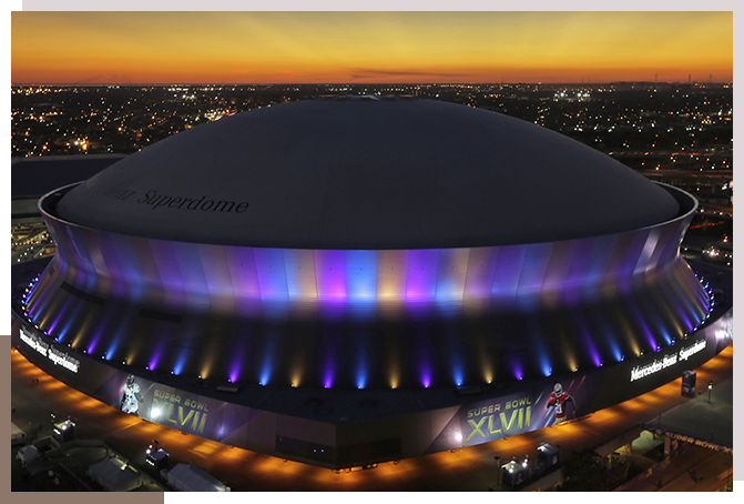 A large stadium with lights on top of it.